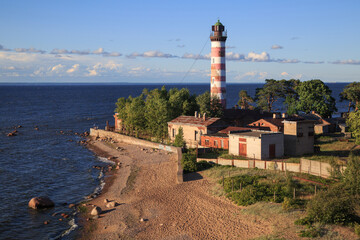 Fototapeta na wymiar Landscape with a lighthouse on the seashore in a summer evening.