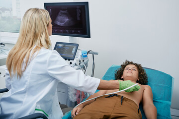 Heart ultrasound exam for male child with ultrasound specialist while medical exam at hospital