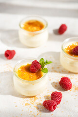 Top view of creme brulee dessert with baked sugar and fresh berries in bright sunshine on linen tablecloth. vertical photo