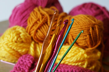 Colorful crotchet hooks with woolen background