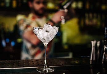 Ice cube in an empty glass on a bar counter in bar or pub