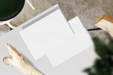Clean minimal A5 flyer mockup on white top table with stick and plant