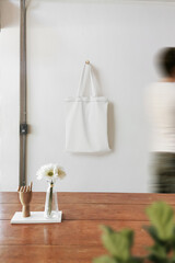 Clean minimal bag canvas hanging mockup on the wall with people and plant