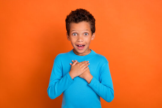 Photo Of Astonished Impressed Boy Arm Breast Unexpected Unbelievable Reaction Win Winner Isolated On Orange Color Background