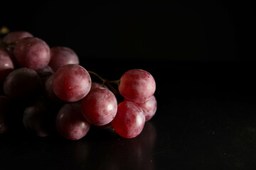 Racimo de uvas de la vendimia sobre fondo oscuro. Espacio para texto. 
