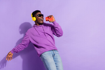 Photo of ecstatic satisfied person hold telephone enjoy new single isolated on purple color...