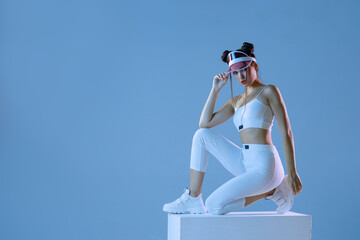 Woman in futuristic sport costume. Augmented reality game, future technology. Neon blue light.