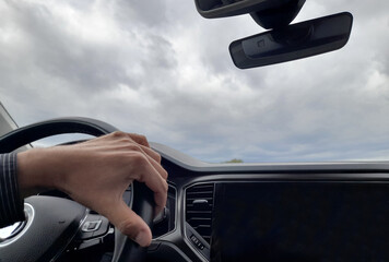 Guidare l'automobile in campagna in una giornata nuvolosa