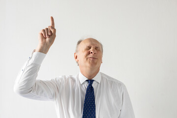 Portrait of delightful mature businessman showing forefinger. against white background. Senior manager wearing formalwear making idea gesture and frowning. Solution and idea concept