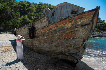 A tourist takes a picture of a shipwreck abandoned at a sea-coast of Skyros island in Greece