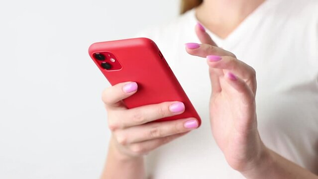 woman swiping red smartphone close-up