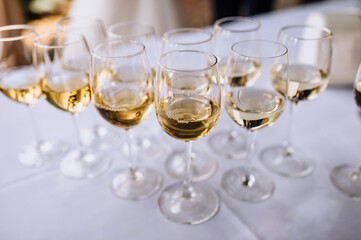A lot, a row of glass glasses with champagne stands on a table in a bar, restaurant. Photography, party.