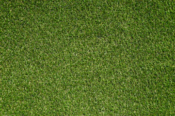 Background, texture of green artificial grass on a meadow for playing football, baseball, soccer, golf.