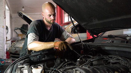 Auto mechanic repairs SUV engine. auto repair station. automobile