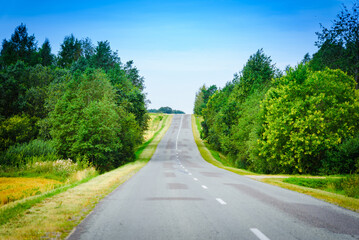 Fototapeta na wymiar A country empty road along with nature,holiday and travel concept.Summer day.
