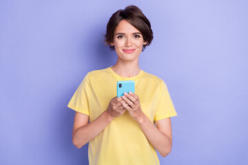 Photo of pretty charming lady hold use telephone chatting typing isolated on violet color background