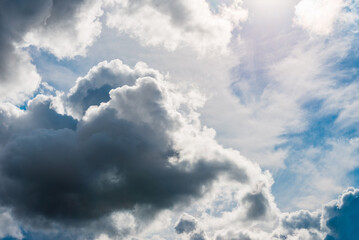 Heavy dark storm raining clouds over the blue sky.