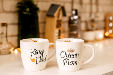 Two white cups stand on the Christmas table in the kitchen