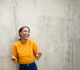 Naklejka na ściany i meble Black woman looking away and laughing outdoors