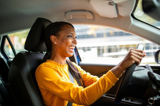 Cheerful black woman driving a car
