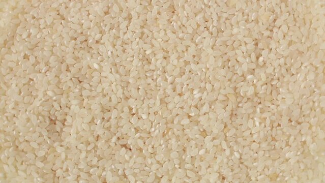 Raw white rice grain food background. 
Rotation. Healthy eating. Top view. Selective focus.