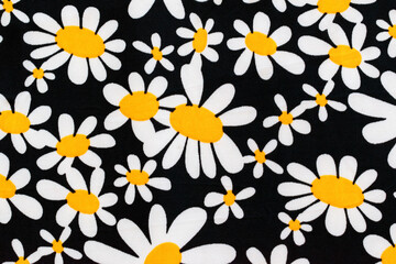 Naklejka na ściany i meble Daisies printed on fabric with black background.