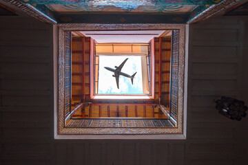 A passenger plane flying over a traditional building - Morocco