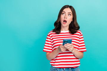 Photo of sweet excited girl dressed red t-shirt communicating modern gadget empty space isolated teal color background