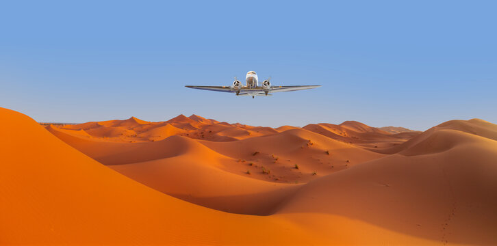 Beautiful sand dunes in the Sahara desert - Sahara, Morocco - Vintage type old metallic propeller airplane in the sky