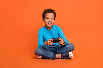 Full length photo of adorable little boy hold joystick playstation enjoy weekend wear trendy blue...