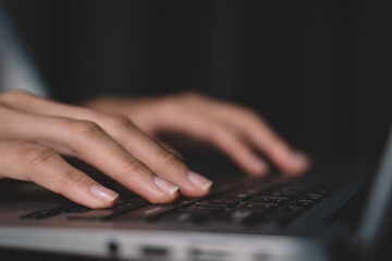 Woman hand typing on keyboard at workplace. Businesswoman working over labtop on a table from wood doing work from home, closeup working hand picture of business communication.