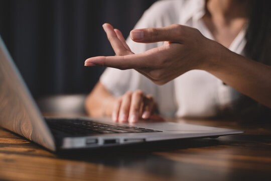 Woman hand typing on keyboard at workplace. Businesswoman working over labtop on a table from wood doing work from home, closeup working hand picture of business communication.