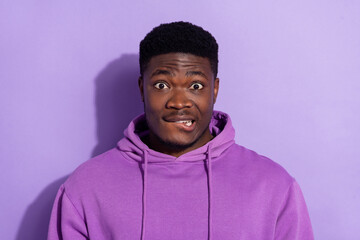 Portrait of attractive funny worried guy biting lip oops isolated over bright violet lilac color...