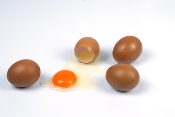 whole eggs and one broken isolated on a white background