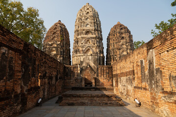 Fototapeta premium Wat Si Sawai temple and pagodas of Thai style architecture, in Sukhothai Historical Park at sunset