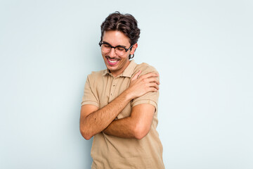 Young hispanic man isolated on blue background laughing and having fun.