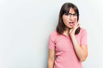 Young caucasian woman isolated on white background shouts loud, keeps eyes opened and hands tense.