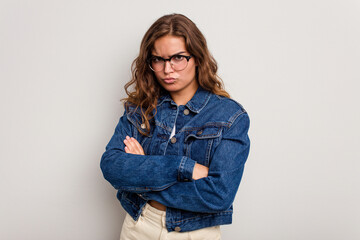 Young caucasian woman isolated on blue background tired of a repetitive task.