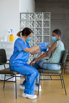 African American Woman Sitting At Doctor's Office And Getting A Flu Shot.