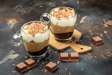 Dessert with three layers chocolates mousse, vanilla, chocolate, creme brulee dessert on a dark background. place for text, top view