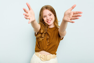 Young caucasian woman isolated on blue background showing a welcome expression.