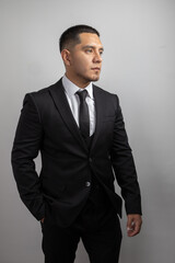 elegant latin young man with short hair and beard, business clothes, suit, shirt and tie, fashion and lifestyle in studio