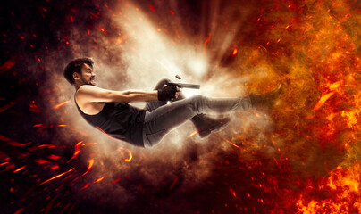 Excited man holding gun. Fire background