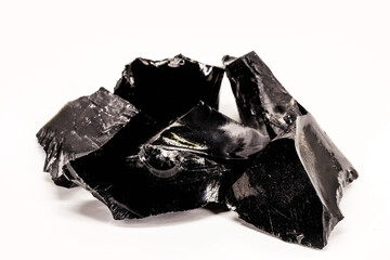 Black Obsidian, black and crystalline ore on isolated white background. Black colored stone, therapeutic, used in meditation.