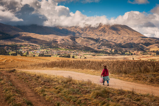 Woman in traditional clothing walking in Sacred Valley of the Incas, Cusco Region, Peru