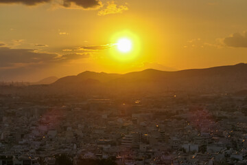 Scenic view during sunset of the city of Athens seen from Filopappou Hill (hill of muses), Athens, Attica, Greece, Europe. Athens cityscape and hilly landscape. Beautiful sunset point with aerial view