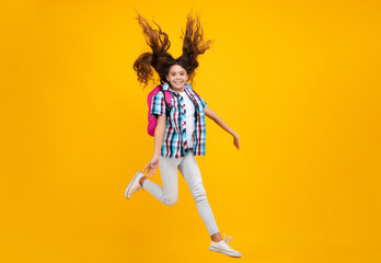 Fototapeta na wymiar Amazed teen girl. Back to school. Teenage school girl ready to learn. School children on yellow isolated background. Run and jump. Excited expression, cheerful and glad.