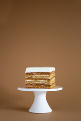 homemade natural honey cake on brown background and cake stand