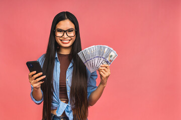 Happy rich winner! Portrait of asian woman holding money dollars bills and smiling satisfied,...