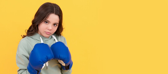 serious child portrait in boxing gloves on yellow background. Horizontal poster of isolated child...